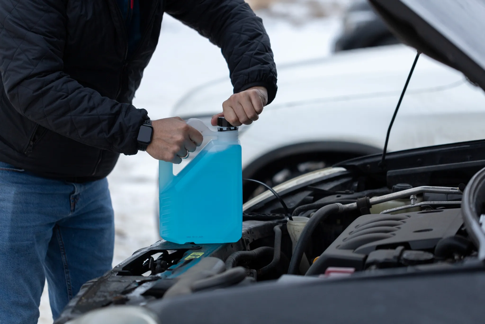 Personne versant du liquide lave-glace